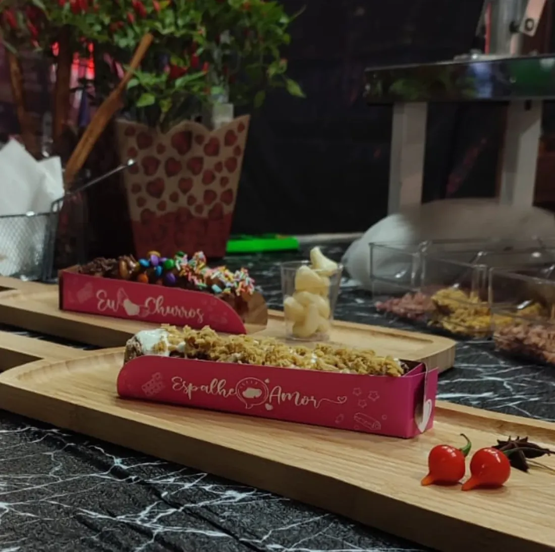 Mesa de churros com coberturas e confeitos