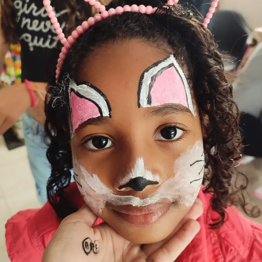 Criança com pintura artística de gatinho no rosto